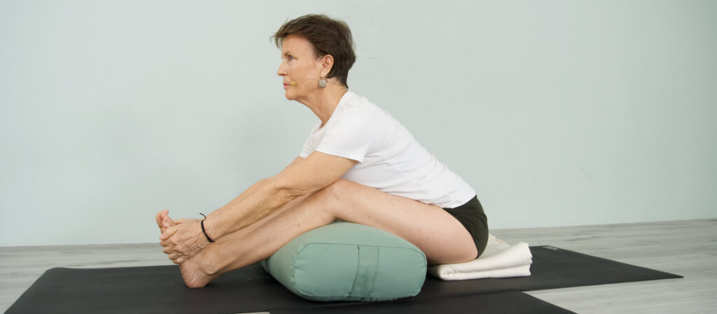 Senior Iyengar Yoga Teacher Kathy Cook demonstrate a Seated Forward Bends Pose