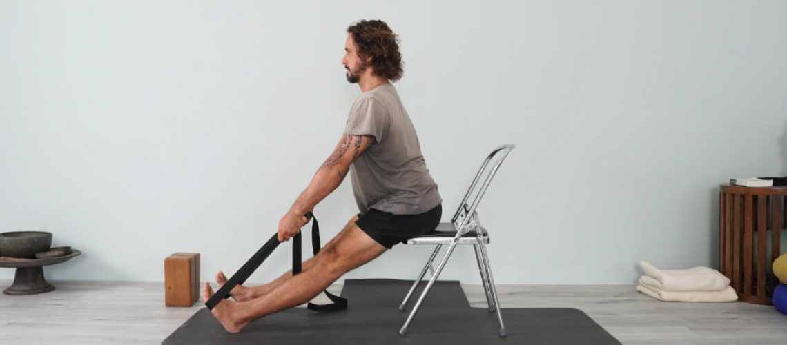 Iyengar Yoga Teacher Juan Carlos doing Forward Bend on chair