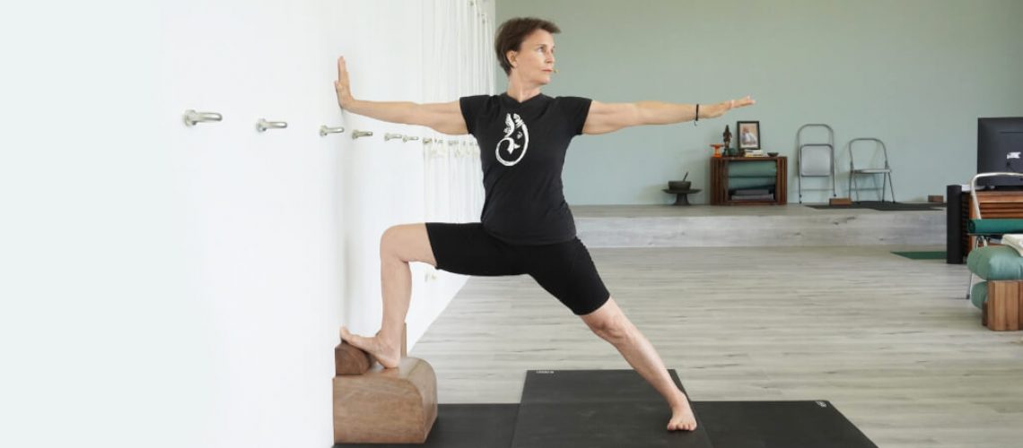 Senior Iyengar Yoga Teacher Kathy Cook demonstrate a Warrior Pose