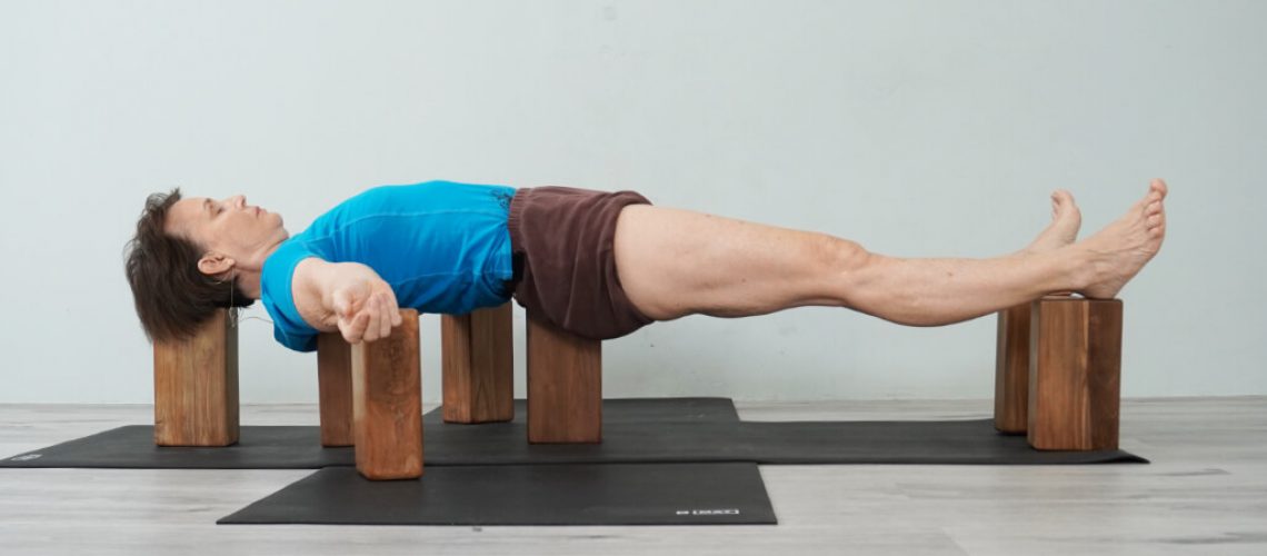 Senior Iyengar Yoga Teacher Kathy Cook demonstrate a Floating Corpse Pose