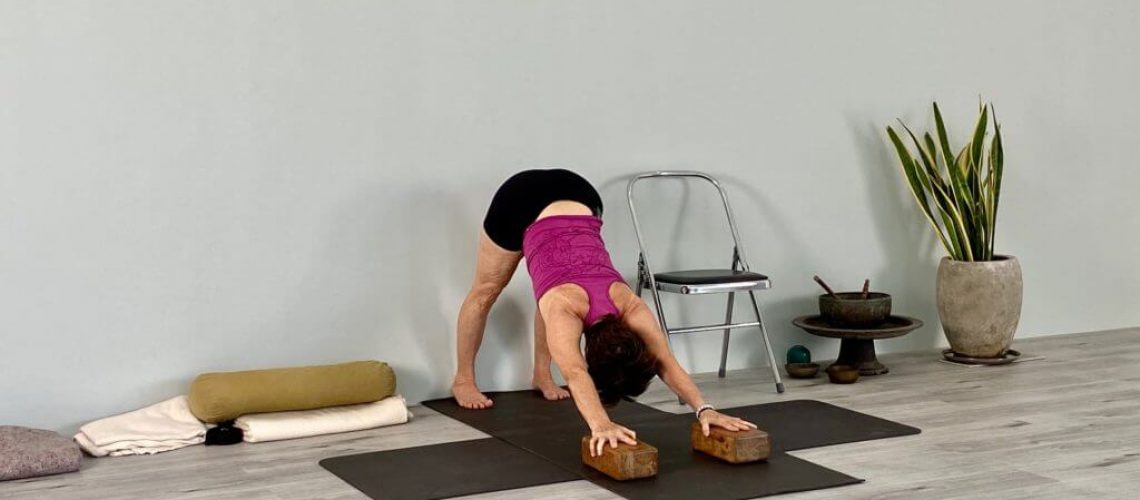 senior iyengar teacher kathy cook in down dog pose